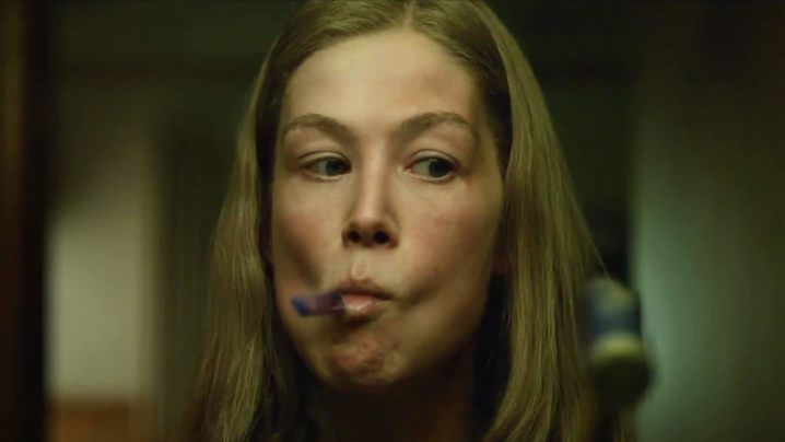 רוזמונד פייק - איימי אליוט דאן עם מברשת שיניים על פיה בסרט נעלמת.