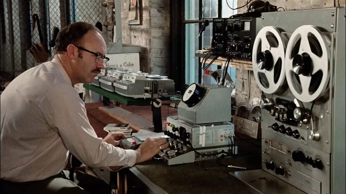Gene Hackman as Harry Caul leaning over a surveillance tape machine in The Conversation.